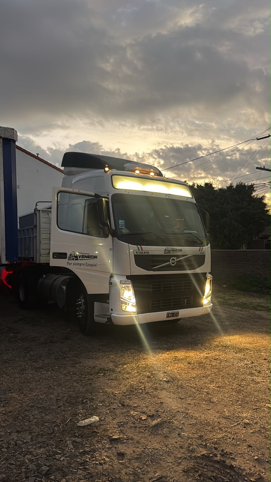 Tractor Volvo FM de Transporte Venecia con las luces encendidas al atardecer